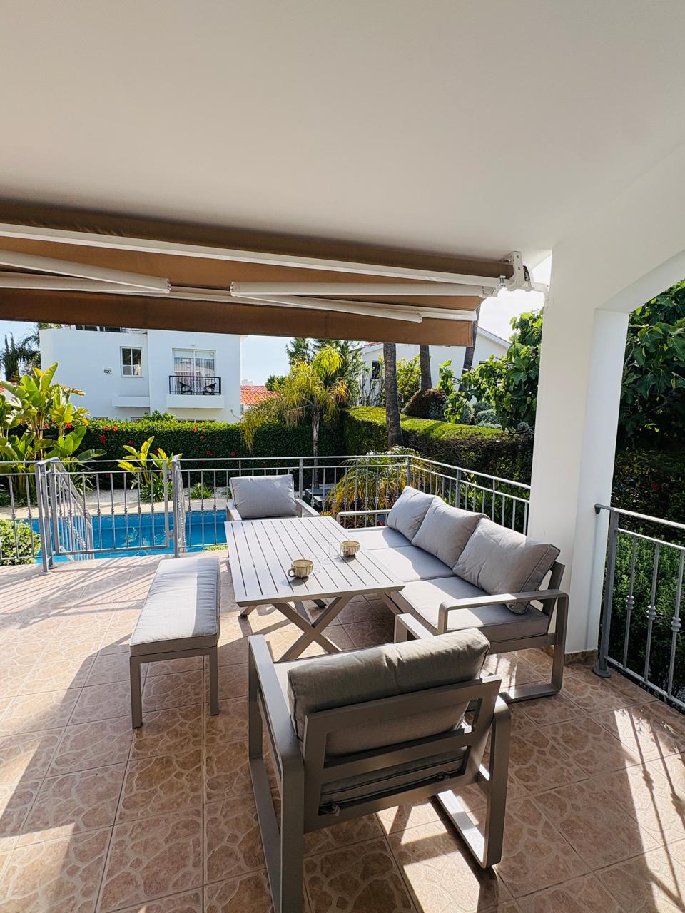 Shaded terrace with comfy seating and poolside garden views