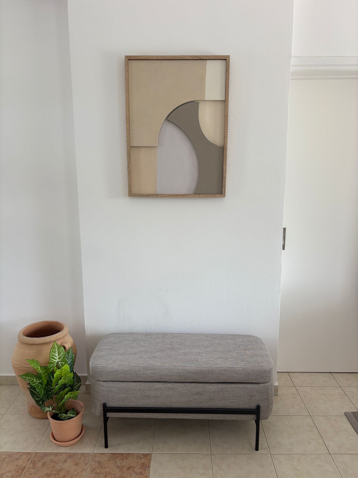 Minimalist entry bench with abstract art and greenery, welcoming and calm