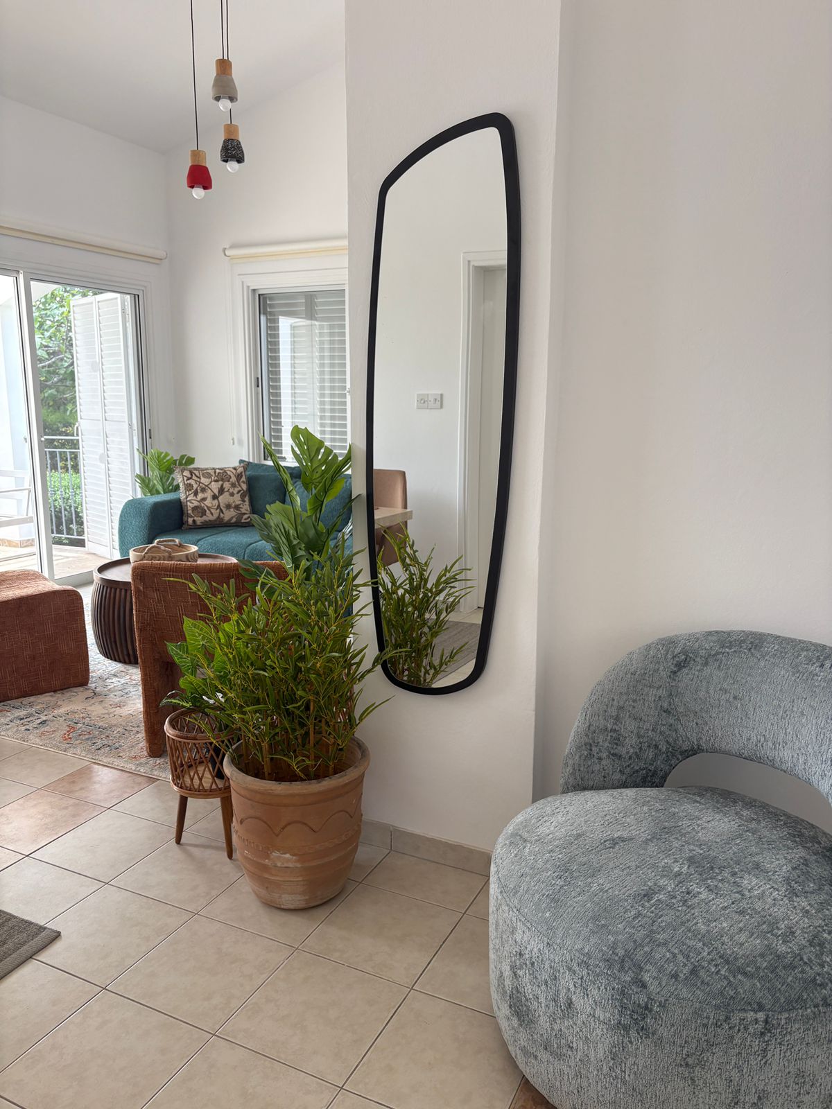 Sunny lounge with balcony access, lush plants & chic cozy seating