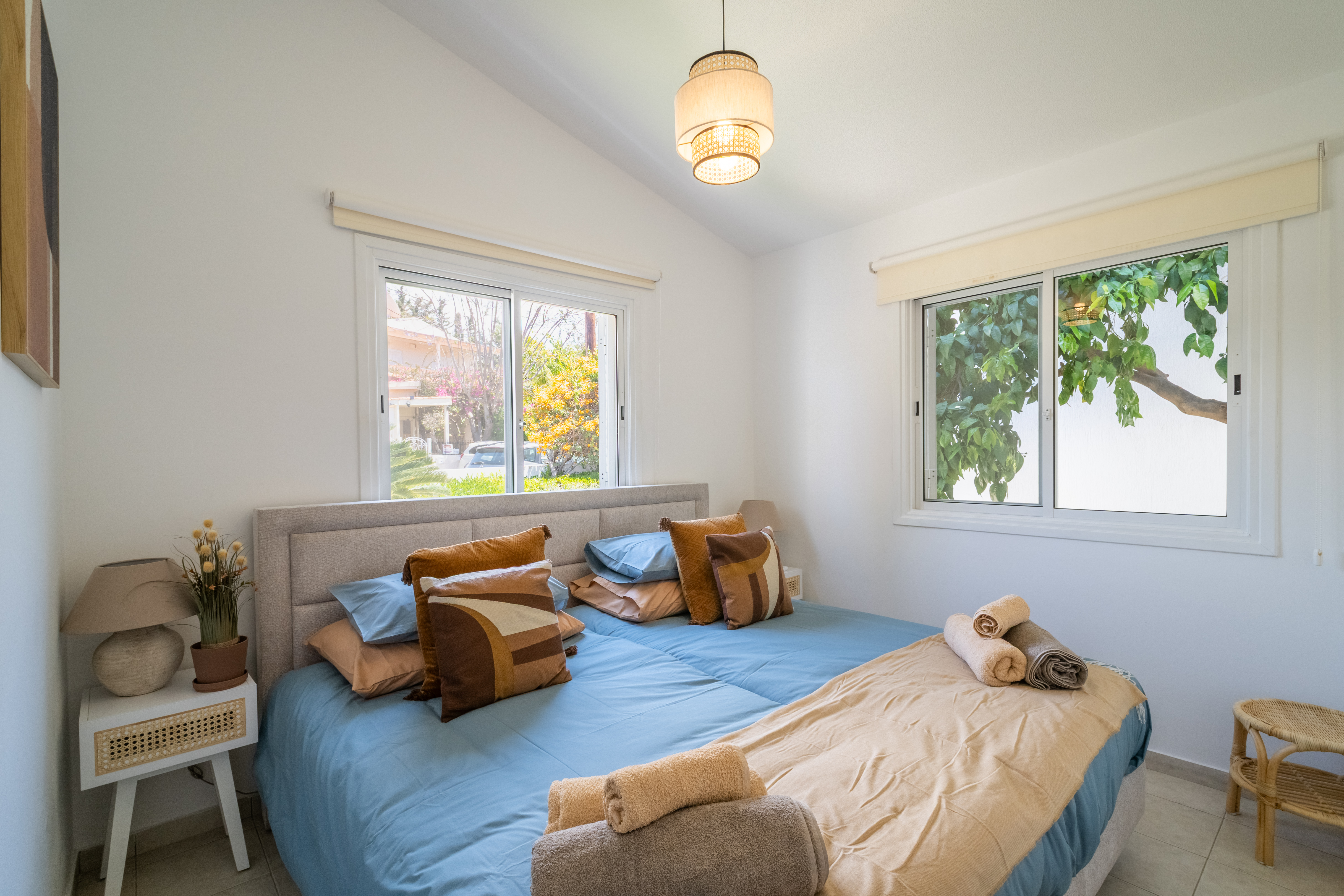 Bright garden-view bedroom with plush king setup and fresh linens
