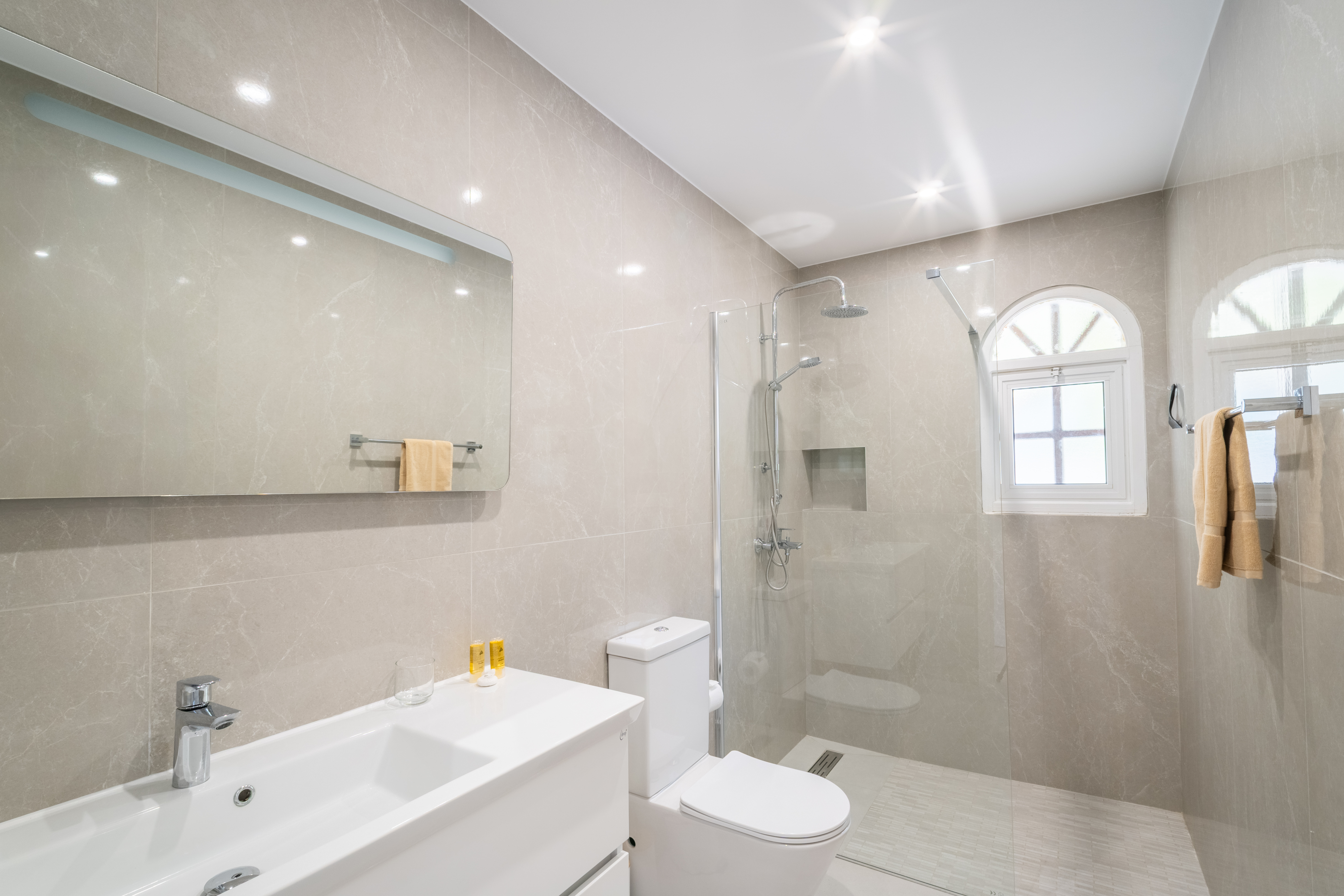 Bright spa-style bath with walk-in rain shower and sleek vanity