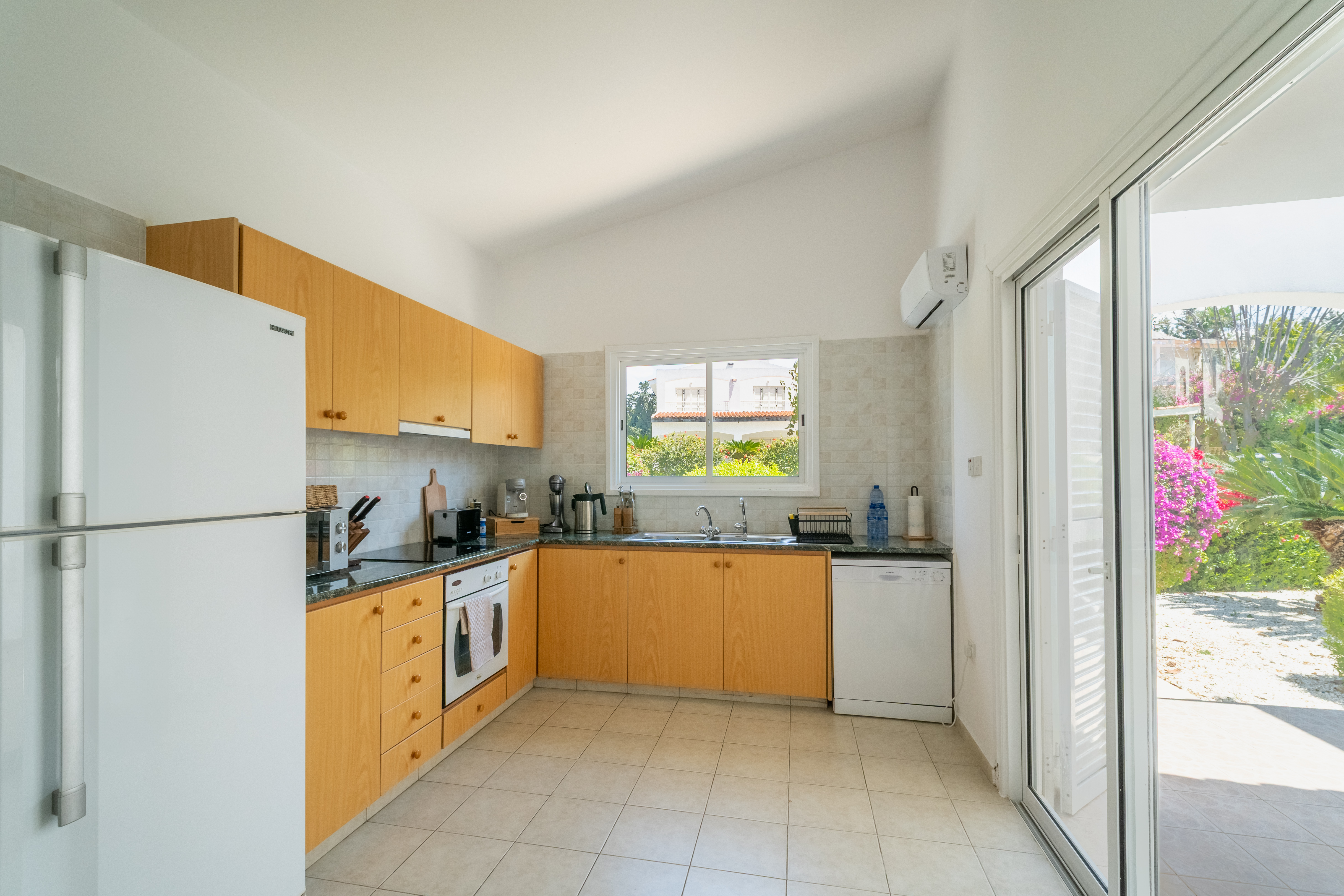 Sunny kitchen with garden access, full fridge, oven & A/C