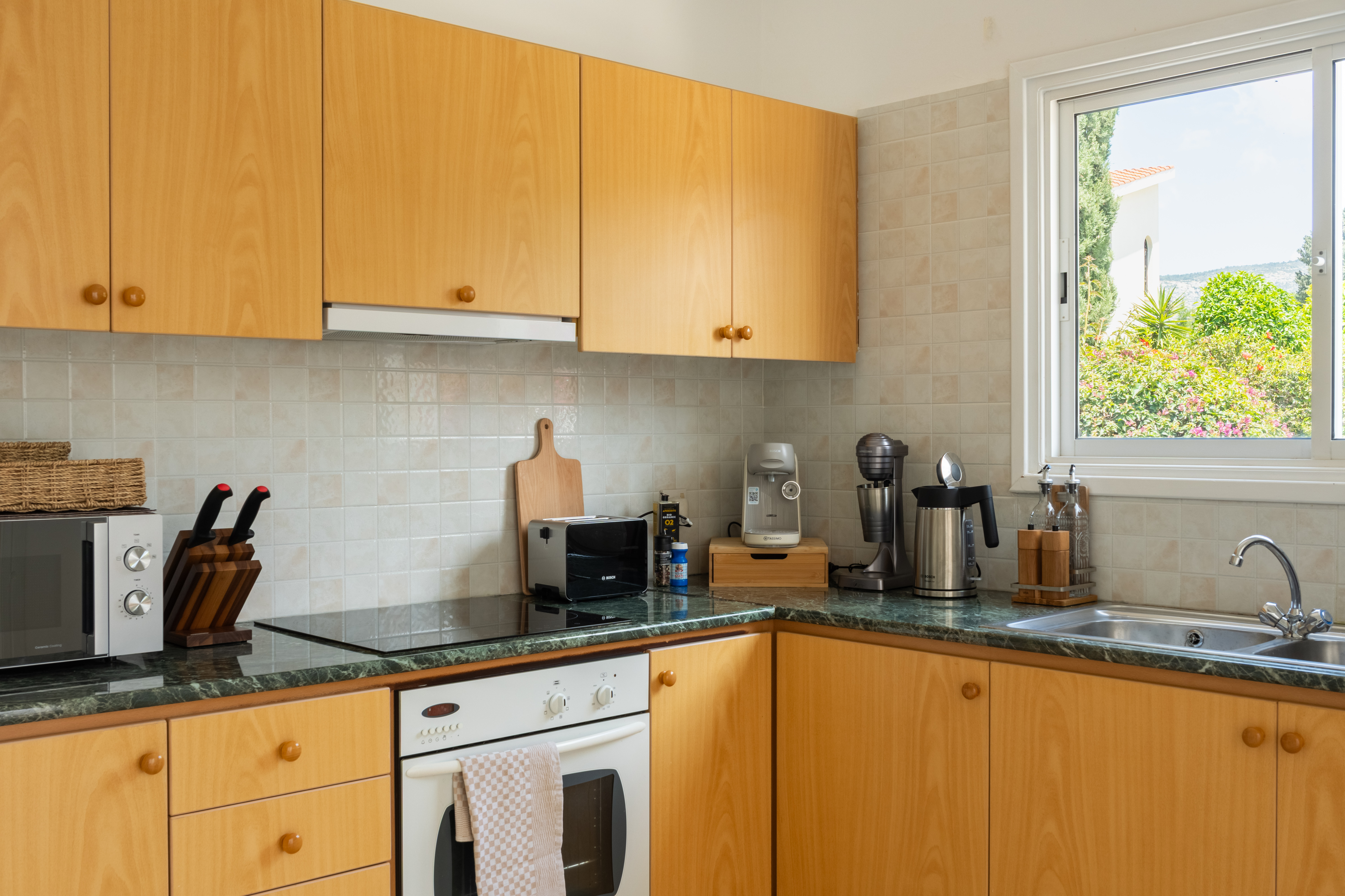 Sunny, fully equipped kitchen with espresso bar and garden view
