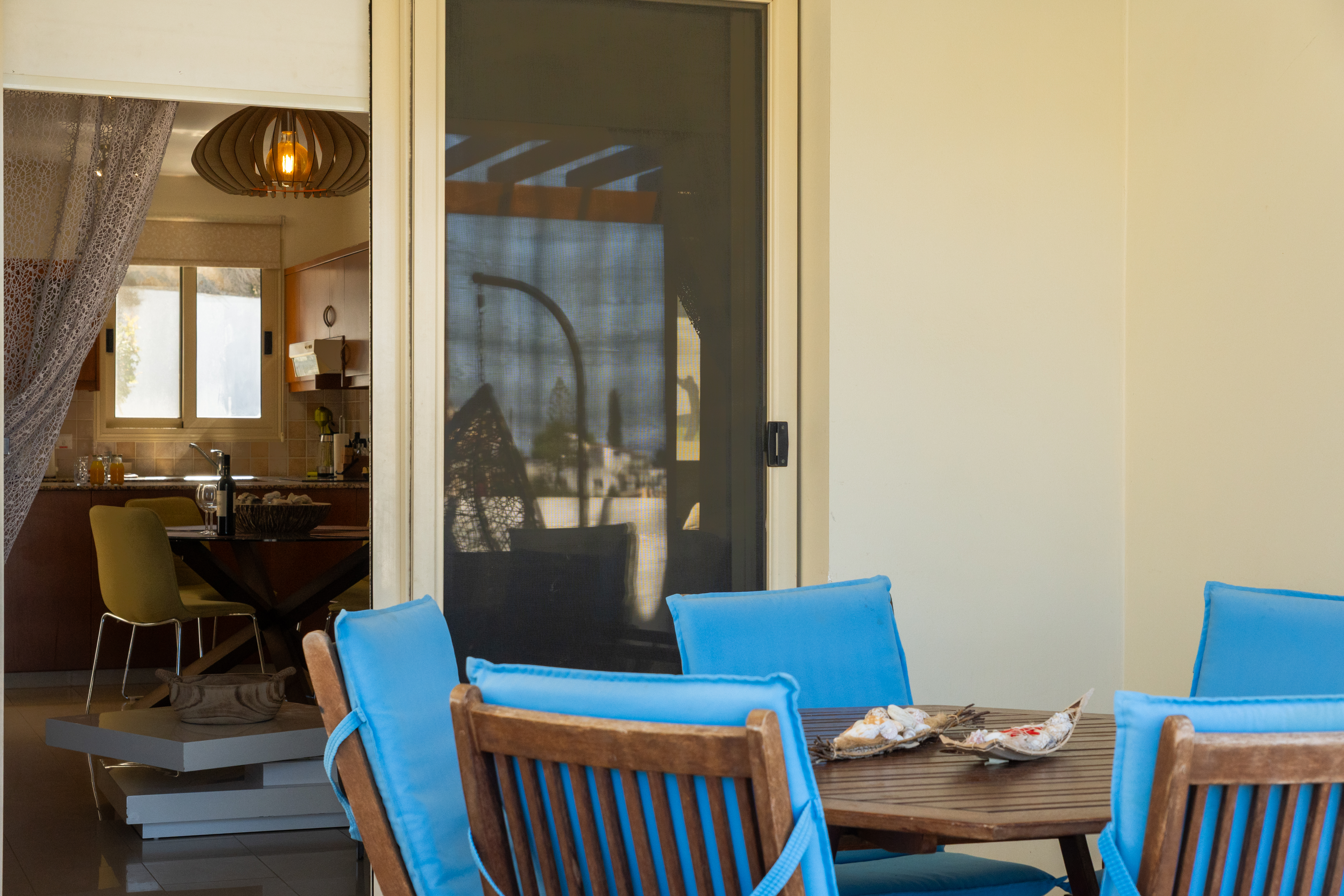 Sunny patio dining + modern kitchen, seamless indoor, outdoor living.