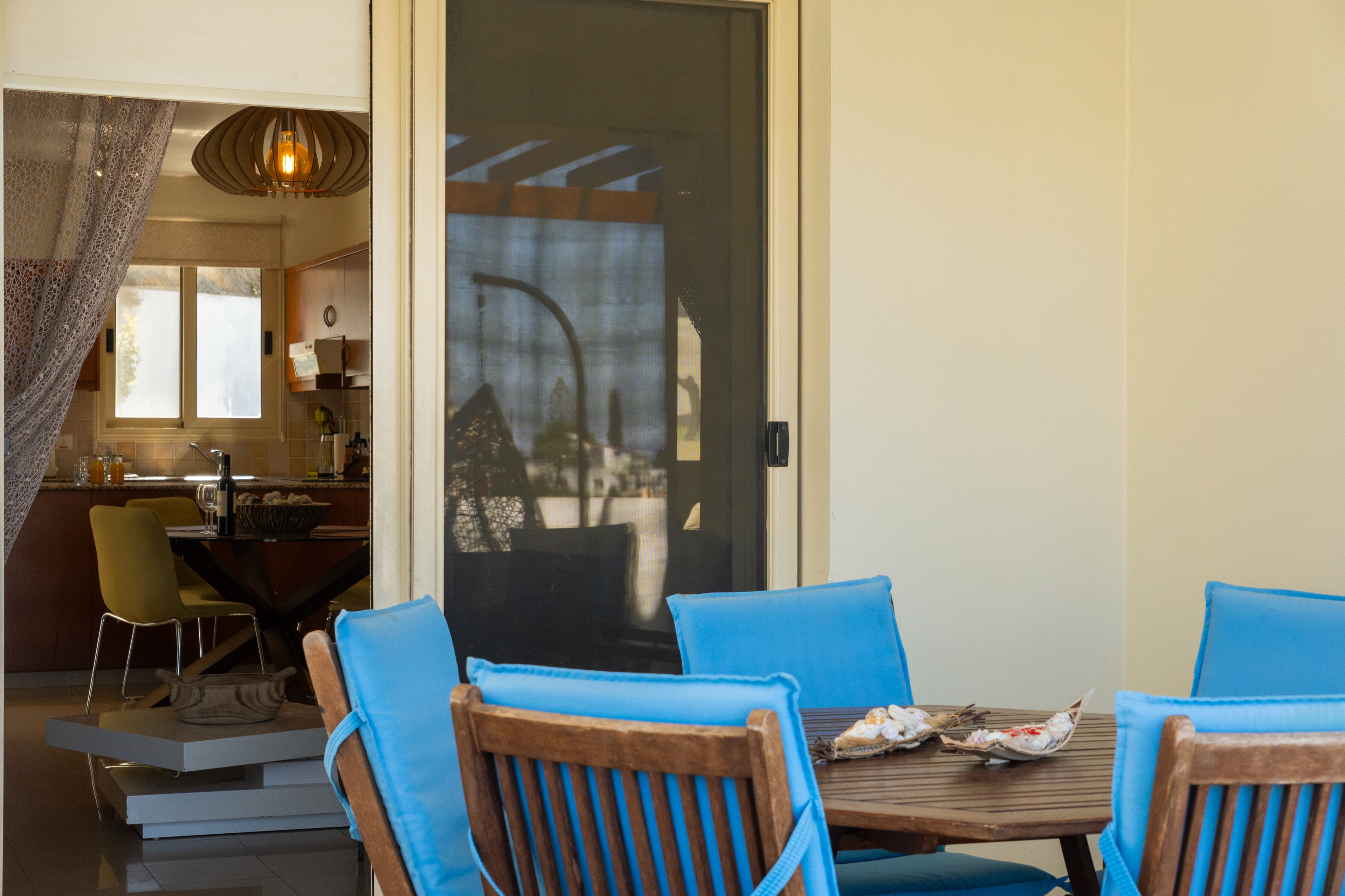 Sunny patio dining + modern kitchen, seamless indoor, outdoor living.
