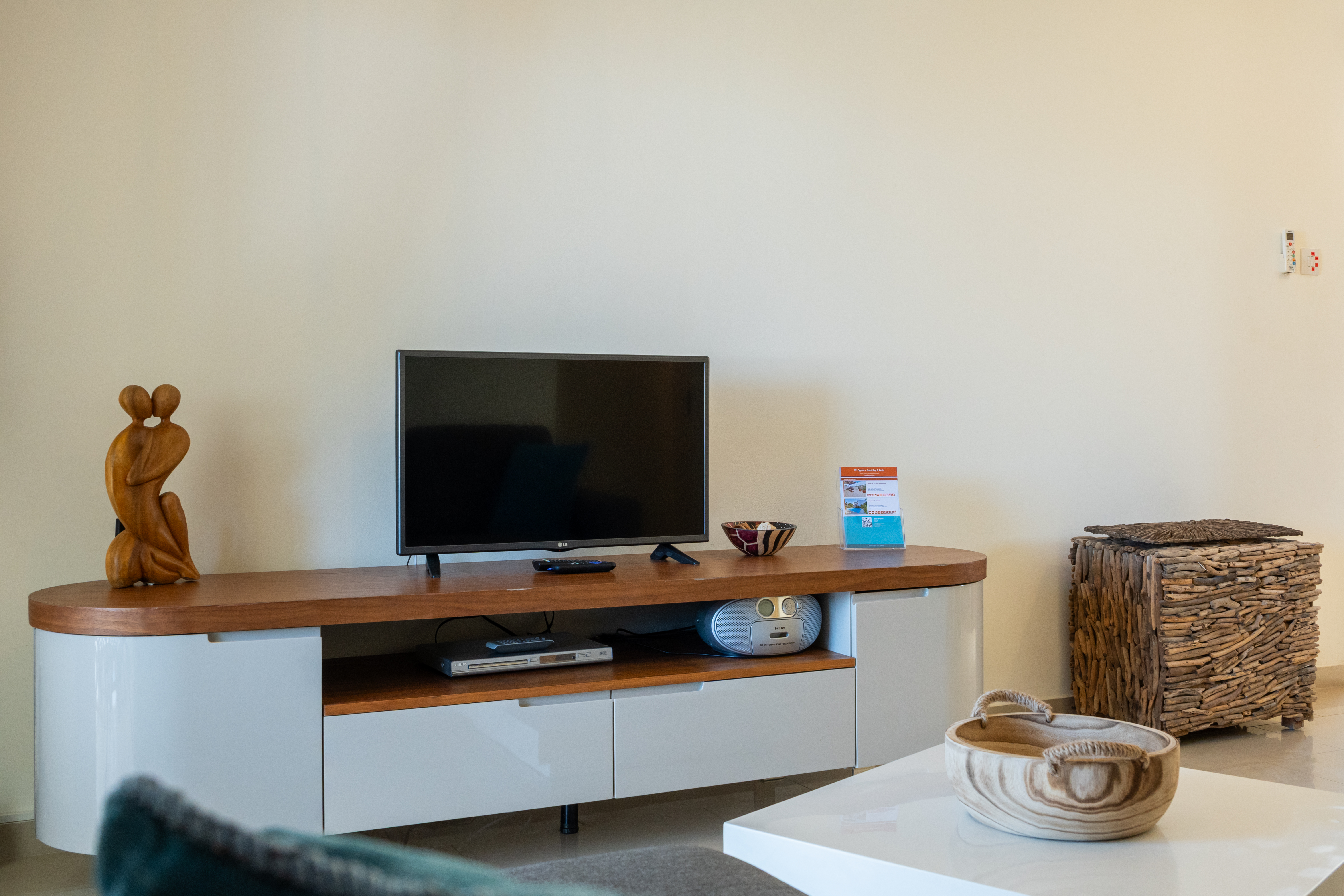 Modern media console with flat-screen TV and warm, artful accents.